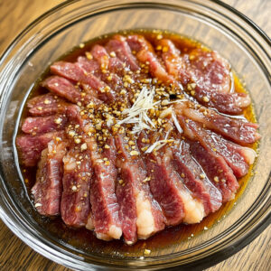 thinly sliced raw steak placed in a shallow glass bowl