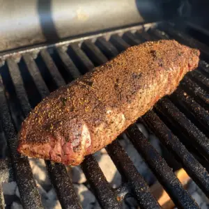 beef tenderloin sizzling on a hot grill