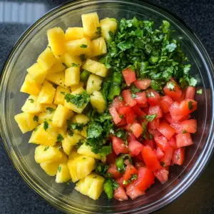 glass mixing bowl filled with freshly diced fruits and veggies