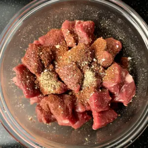 raw beef chunks in a glass mixing bowl