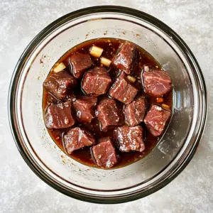 raw beef cubes marinating in a rich, glossy sauce