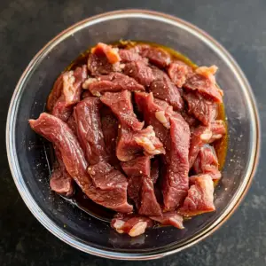 shallow glass bowl filled with a rich, dark marinade