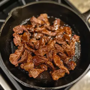 sizzling, thinly sliced beef coated in a rich, reddish brown BBQ sauce
