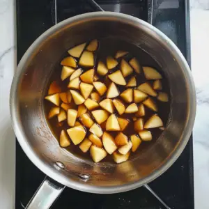 Diced apples simmer in a cinnamon flecked syrup