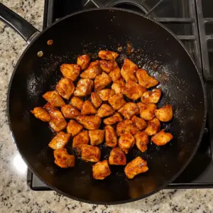 cubed chicken pieces marinated in a light brown soy-based sauce