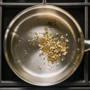 cumin seeds and finely chopped onions sizzle in a small amount of shimmering oil
