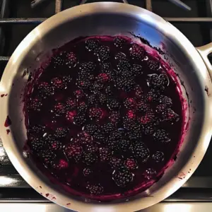 fresh blackberries are simmering in apple juice