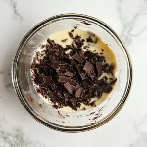 glass mixing bowl filled with finely chopped dark chocolate