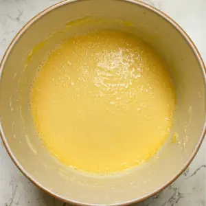 golden mixture of eggs, sugar, melted butter, and vanilla extract