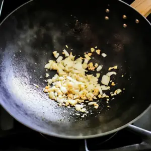 minced garlic and grated ginger sizzling in hot oil