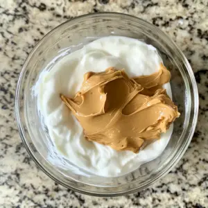 mixing bowl containing thick, creamy Greek yogurt and smooth peanut butter