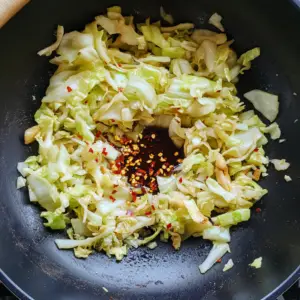 sautéed shredded cabbage, minced garlic, and grated ginger glistening in oil