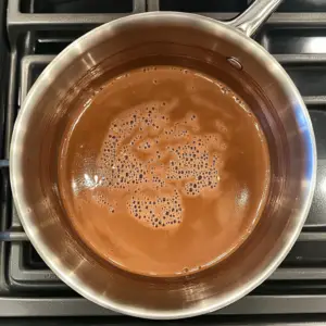 simmering mixture of milk, heavy cream, cocoa powder, and sugar