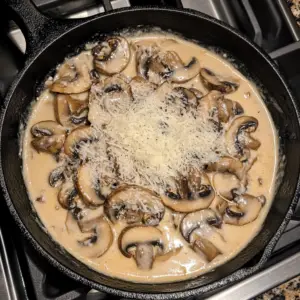 sliced cremini mushrooms simmering in a thick, velvety cream sauce