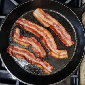 slices of bacon sizzling in hot oil
