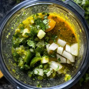blender filled with fresh green ingredients
