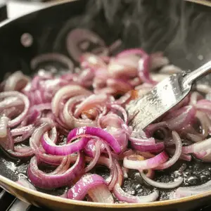 sliced red onions are being fried