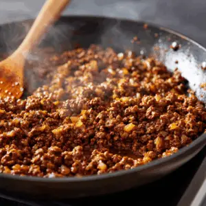 skillet filled with fully cooked, browned ground beef