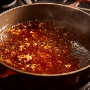 simmering mixture of softened onions and garlic coated in tomato paste